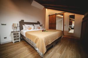 ein Schlafzimmer mit einem großen Bett und Holzboden in der Unterkunft Posada La Corralada in Pámanes