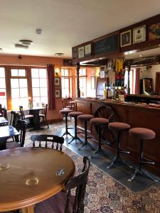 a restaurant with a bar and tables and chairs at The Old Stables Pub with rooms in Moffat