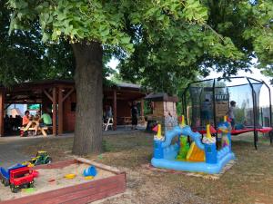 uma área de recreação infantil com um parque infantil e uma árvore em Hotel Trilobit em Veselí nad Luznicí