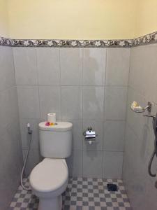 ウブドにあるHendra Houseのタイルフロアのバスルーム(白いトイレ付)