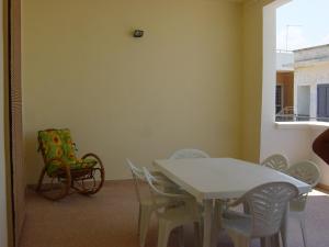 um quarto com uma mesa branca, cadeiras e uma cadeira em Casa vacanza Casalabate em Casalabate