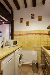 uma cozinha com máquina de lavar e micro-ondas em Apartment Saint Jacques Notre Dame de Paris em Paris