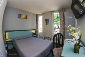a small bedroom with a bed and a table with a desk at hotel des 2 nations in Luchon