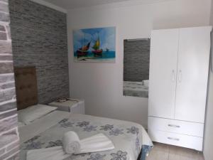 a bedroom with a bed and a white cabinet at Suítes São Francisco in Porto De Galinhas