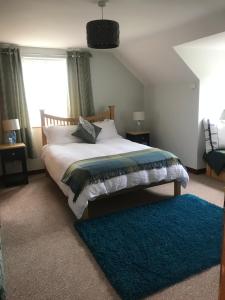 una camera con letto e tappeto blu di Muff Village Bed & Breakfast a Muff