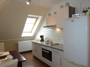 a kitchen with a white refrigerator and a table at Ferienwohnung Sommerwind in Klütz