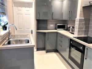 a kitchen with a sink and a microwave at Eclipse House in Newmarket