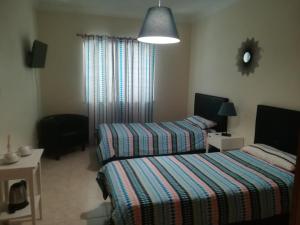 um quarto com 2 camas e um candeeiro em My Guest House em Portimão