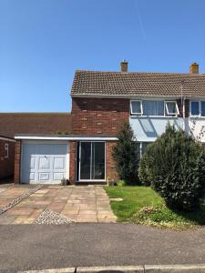 ein Backsteinhaus mit einer Garage und einer Auffahrt in der Unterkunft Idyllic 3-bed House. 5-min from Channel Tunnel in Folkestone