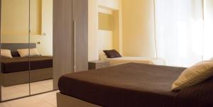 a bedroom with a bed and a couch and a mirror at Guerrini Hotel in Castiglioncello
