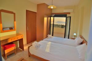 a bedroom with a bed and a desk and a mirror at Xenios Zeus Apartments in Kissamos