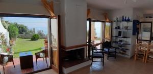 salon z kominkiem i przesuwnymi szklanymi drzwiami w obiekcie Joanna's Seaside Villa w mieście Kallithea