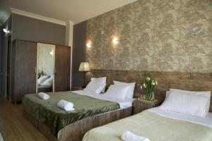 a hotel room with two beds and a mirror at Terassa Hotel Kobuleti in Kobuleti