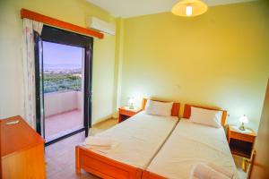 a bedroom with a bed and a door to a balcony at Xenios Zeus Apartments in Kissamos