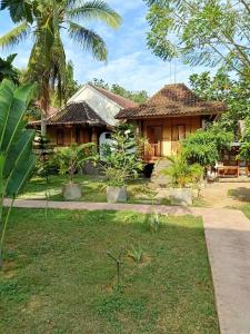 una casa con un jardín delante de ella en Tri Putri Homestay, en Kuta Lombok