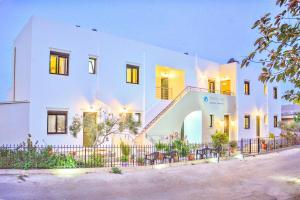 a white building with a fence in front of it at Xenios Zeus Apartments in Kissamos