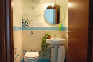 ein Badezimmer mit einem Waschbecken, einem WC und einem Spiegel in der Unterkunft Latt e Liett in Neapel