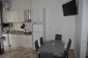 a kitchen with a table and chairs and a kitchen with white cabinets at apartamento agaete Beach 4a in Agaete +4 photos