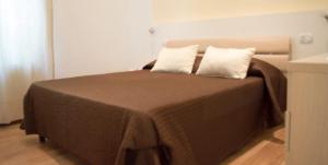 a bed with two pillows on it in a room at Guerrini Hotel in Castiglioncello