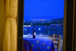 a table with two glasses and a bottle of wine at Xenios Zeus Apartments in Kissamos