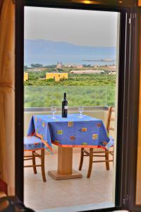 a bottle of wine sitting on a table with two chairs at Xenios Zeus Apartments in Kissamos