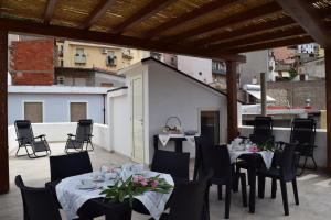 patio z 2 stołami i krzesłami z kwiatami w obiekcie Tesori di Sardegna w mieście Baunei