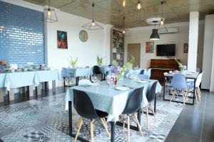 a restaurant with tables and chairs and a piano at Terassa Hotel Kobuleti in Kobuleti