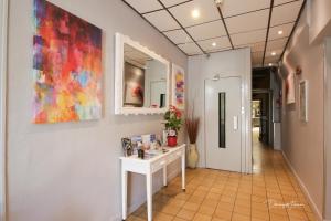 a hallway with a white table and a painting on the wall at hotel des 2 nations in Luchon