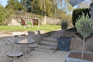 eine Terrasse mit einem Tisch und Stühlen im Hof in der Unterkunft Le MAGNOLIA in La Croix-en-Touraine