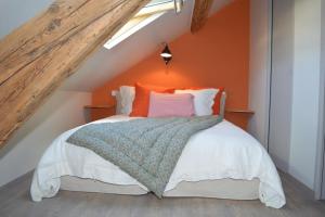 ein Schlafzimmer mit einem Bett mit einer orangefarbenen Wand in der Unterkunft Le MAGNOLIA in La Croix-en-Touraine