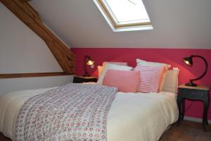 ein Schlafzimmer mit einem großen Bett mit einer roten Wand in der Unterkunft Le MAGNOLIA in La Croix-en-Touraine