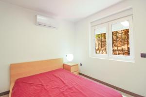 Un dormitorio con una cama roja y dos ventanas. en MAR23J, en La Canuta 7 fotos más