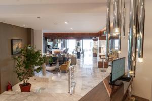 Poseidon Hotel في Kamínia: غرفة معيشة مع أريكة وتلفزيون في مبنى