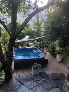 una bañera de hidromasaje en una terraza de madera con un árbol en La Ferme d'Angele, en Bourg-Saint-Maurice
