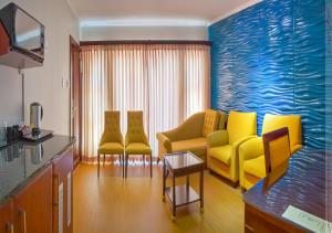 a living room with yellow chairs and a couch at The Royal Courtyard in Matatiele