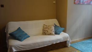 un divano bianco con quattro cuscini sopra di Chojnice - mieszkanie w kamienicy a Chojnice