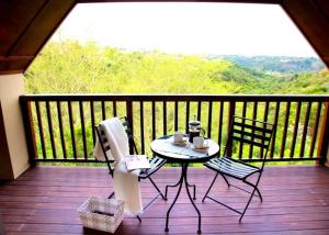 una mesa y sillas en un porche con vistas en WarmKaros Bed & Breakfast, en East London