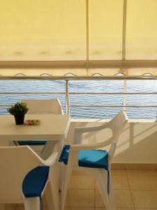 una mesa y sillas en un barco con vistas al océano en Matin Apartment Sea View, en Durrës