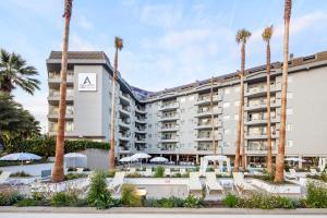 a hotel with palm trees in front of it at AQUA Hotel Montagut Suites 4*Sup in Santa Susanna