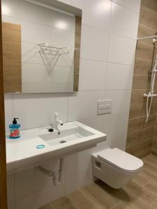 Baño blanco con lavabo y aseo en Garnica5 Suites, en Torrelavega
