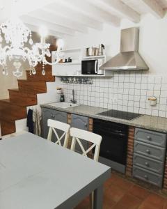 a kitchen with a table and a stove top oven at Alojamiento San Juan Bautista in Cazorla