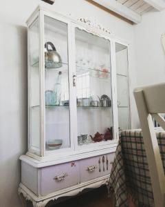 a white cabinet with dishes in it at Alojamiento San Juan Bautista in Cazorla