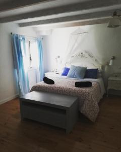 a bedroom with a bed with blue pillows and a window at Alojamiento San Juan Bautista in Cazorla