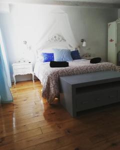 1 dormitorio con cama blanca y suelo de madera en Alojamiento San Juan Bautista en Cazorla