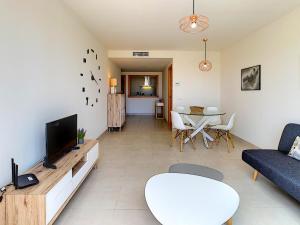 a living room with a couch and a tv and a table at Mundo Aguilon 1 Chambre 4100 in San Juan de los Terreros