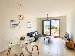 a living room with a glass table and a blue couch at Mundo Aguilon 1 Chambre 4100 in San Juan de los Terreros