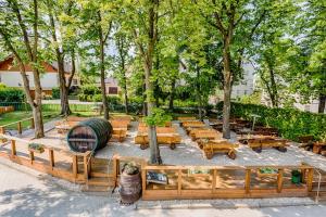 un parque con mesas de madera, bancos y árboles en Brauerei Zwönitz en Zwönitz