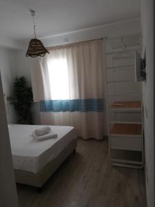 a small bedroom with a bed and a window at B&B Green House in Villasimius