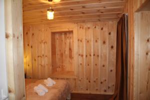 um quarto com paredes de madeira e toalhas numa cama em Ecohouse Svaneti em Mestia