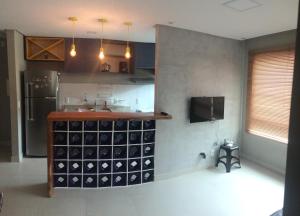 a kitchen with a counter with a bunch of wine bottles at Conforto - VOG Torres do Sul Ilhéus in Ilhéus